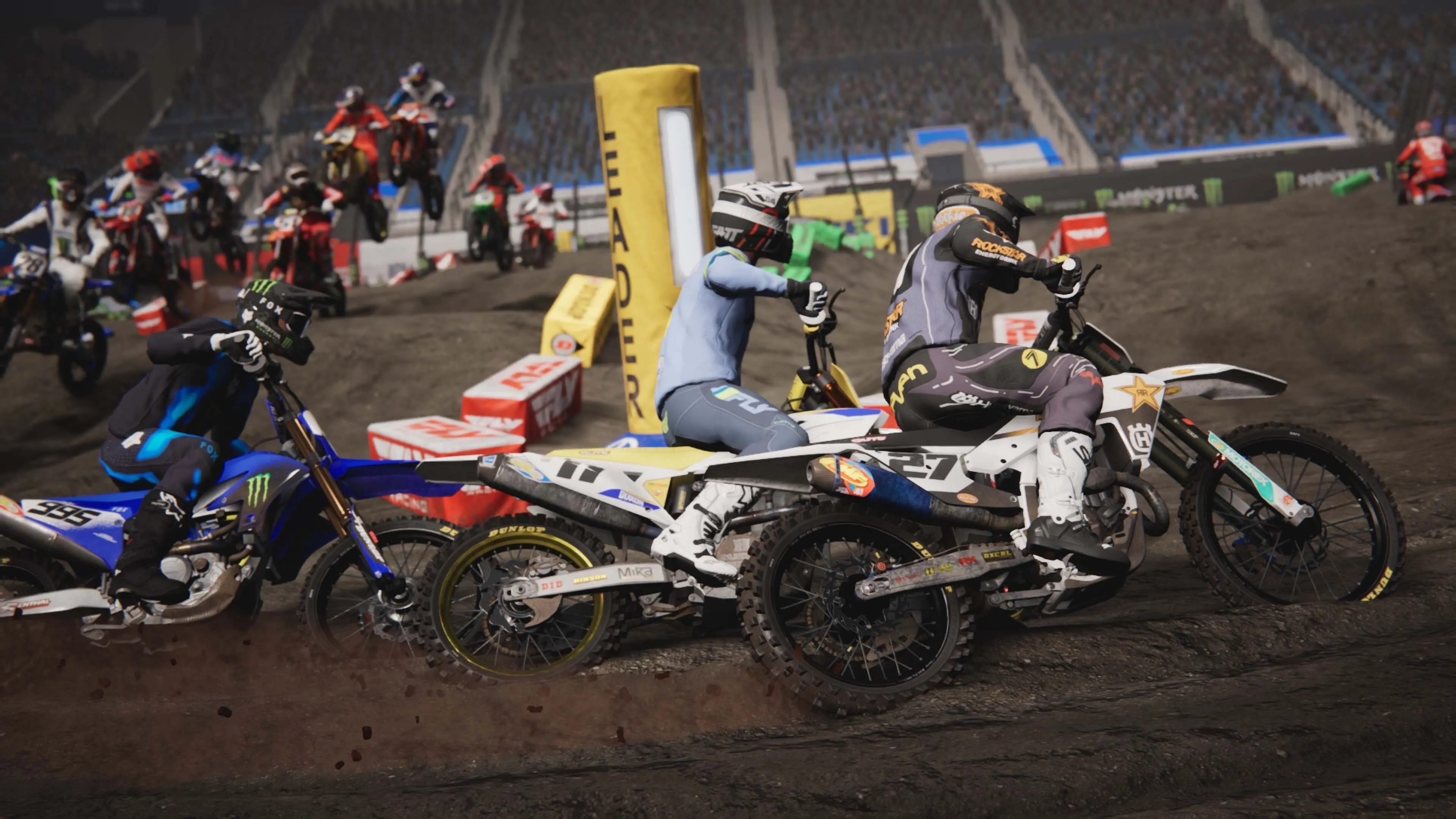 Cận cảnh một tay đua trong Monster Energy Supercross 25 đang tăng tốc trên đường đua đầy bùn đất, thể hiện chi tiết đồ họa và hiệu ứng vật lý của game.