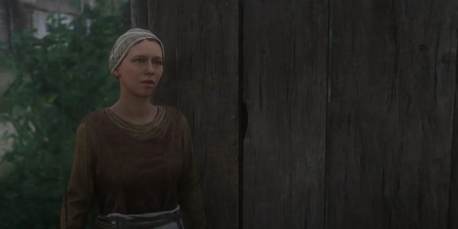 Martha, vợ của thợ rèn, đang đứng trong nhà của mình trong Kingdom Come Deliverance 2