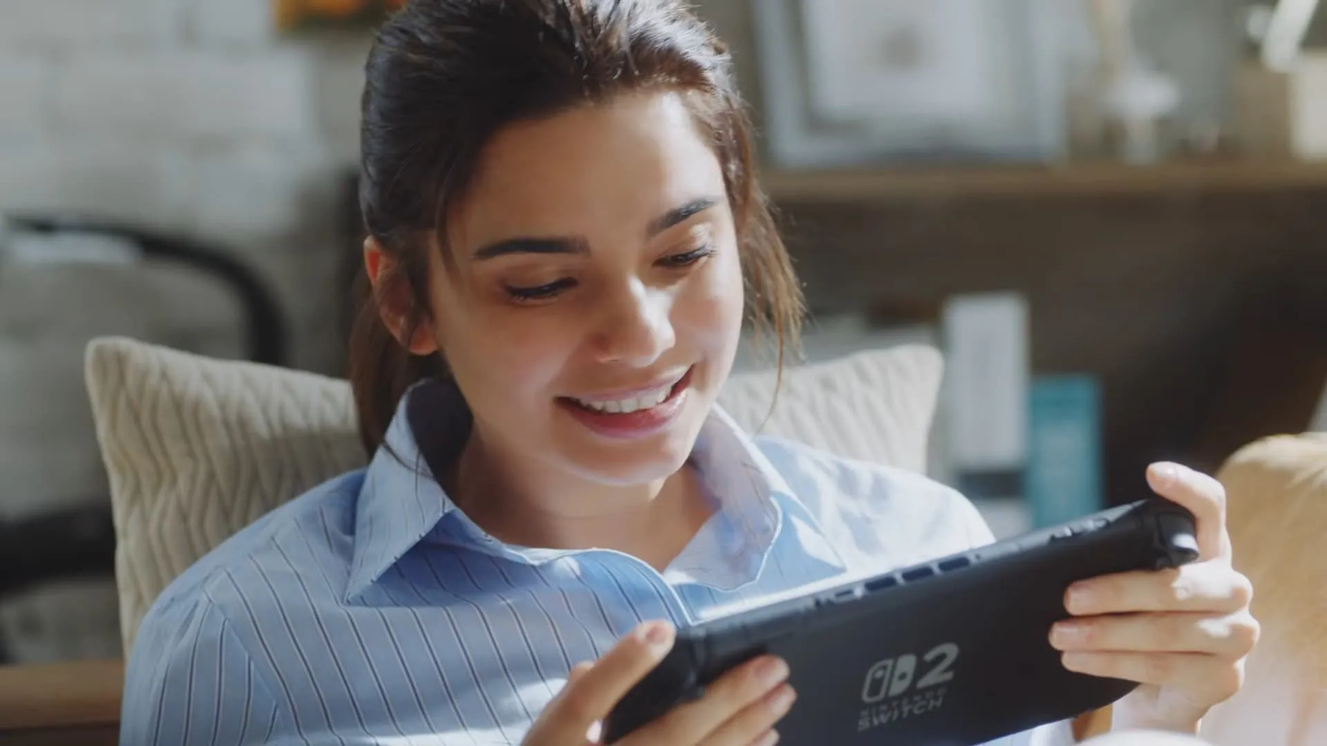 Người chơi đang sử dụng Nintendo Switch 2 ở chế độ cầm tay để trò chuyện nhóm trong game