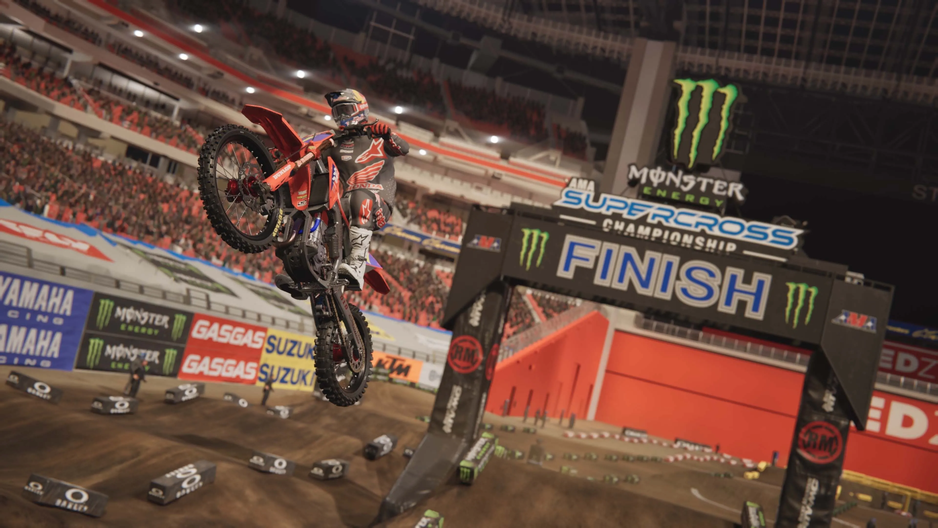 Tay đua trong Monster Energy Supercross 25 ăn mừng chiến thắng khi cán đích, pháo hoa rực sáng trên khán đài, cho thấy hiệu ứng hình ảnh ấn tượng của game.