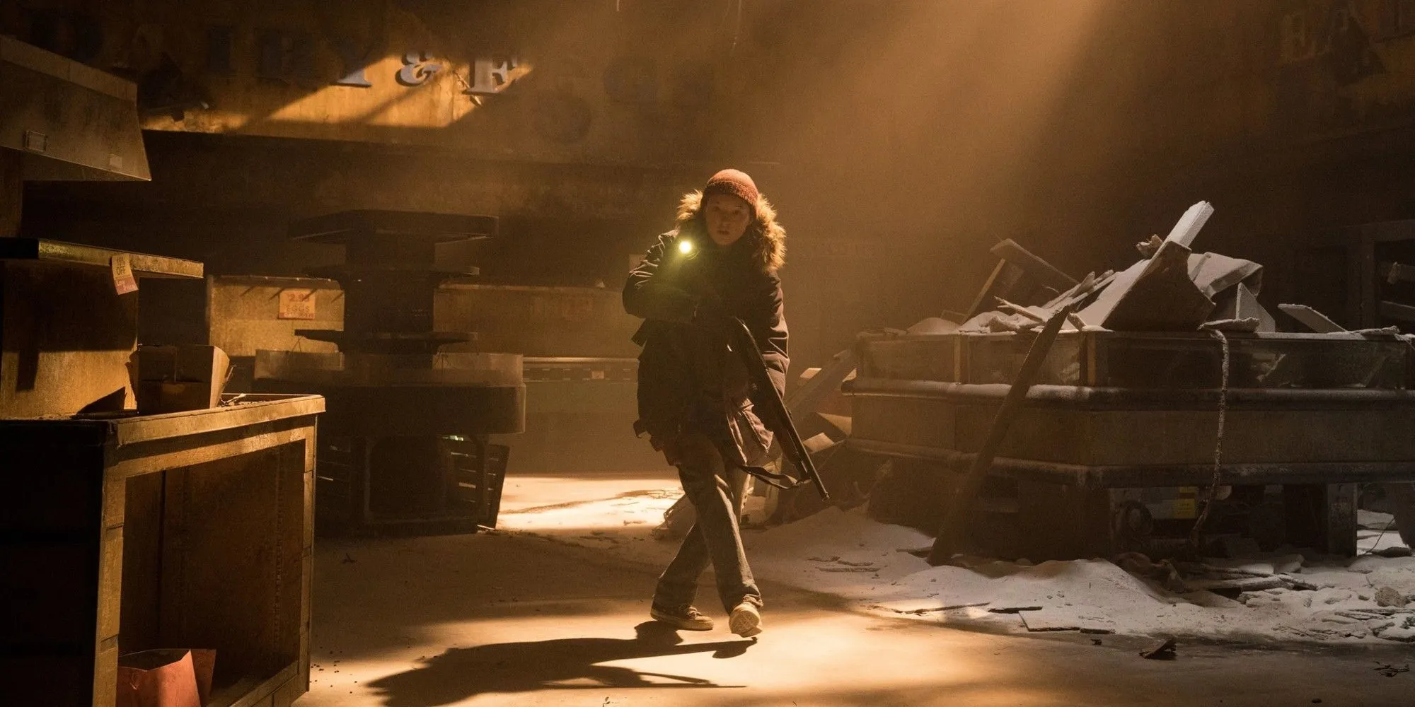Ellie với khẩu súng đi xuyên qua tòa nhà hoang tàn trong The Last of Us Season 2