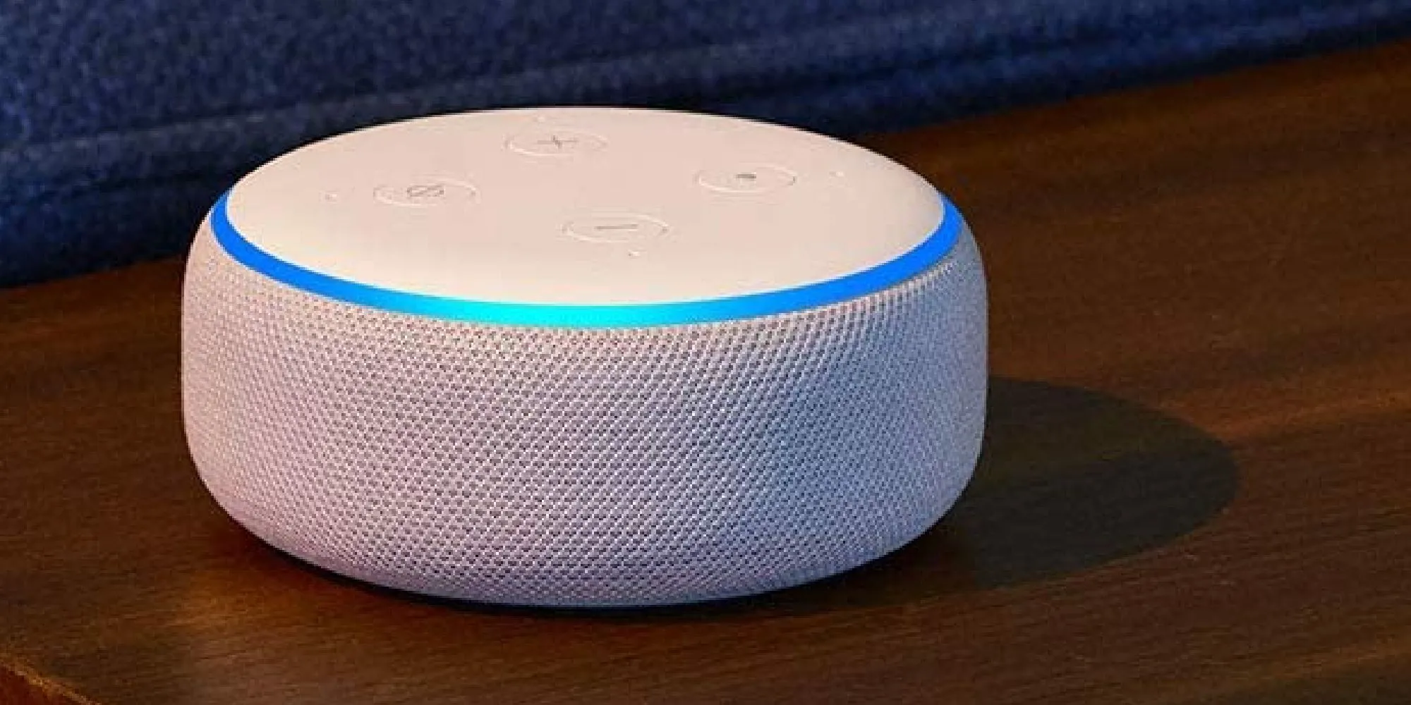 Thiết bị loa thông minh Amazon Alexa màu trắng đặt trên bề mặt gỗ