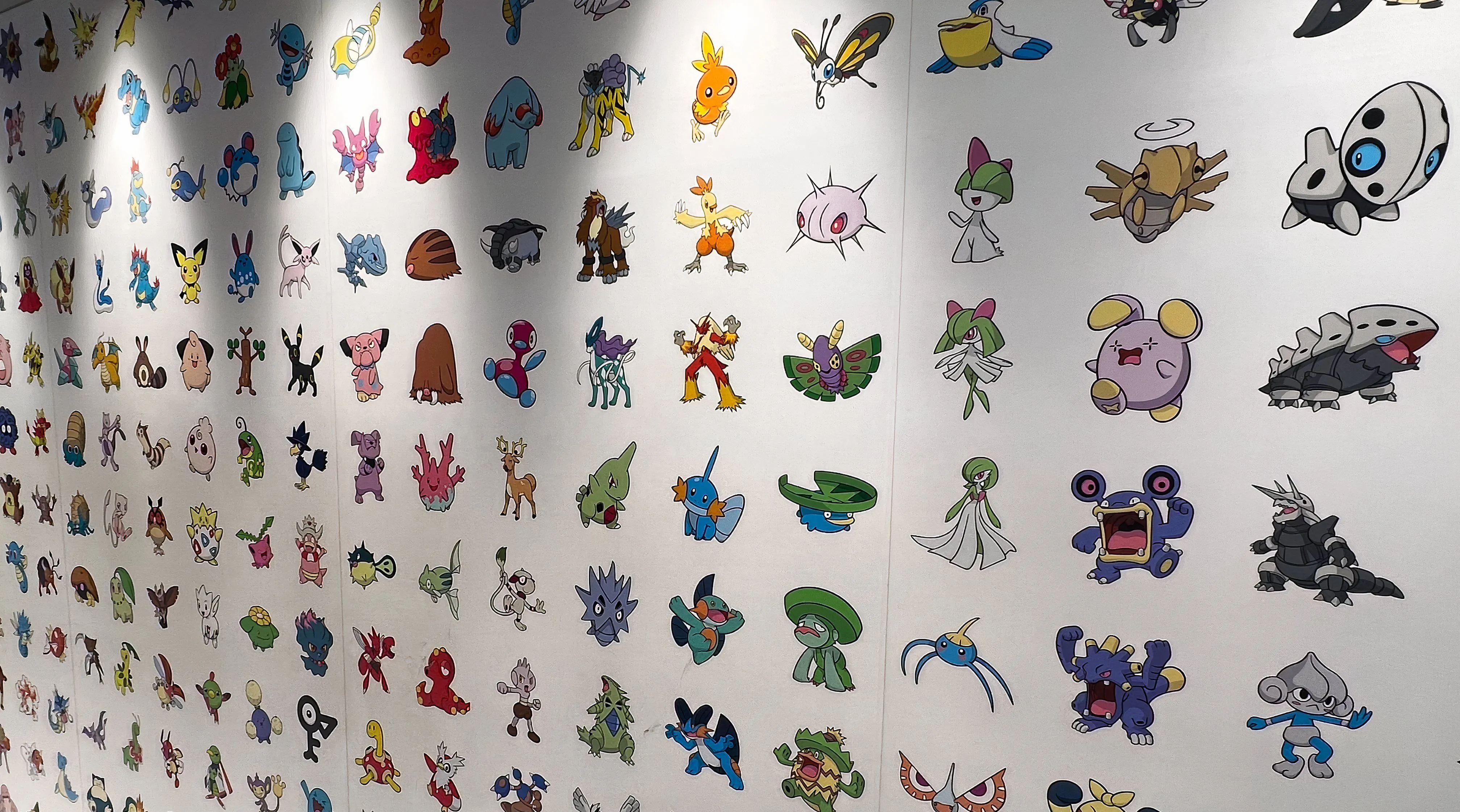 Bức tranh tường giới thiệu các thế hệ Pokemon tại một cửa hàng Nhật Bản, cảnh tượng phổ biến khi đi khảo sát các cửa hàng TCG.