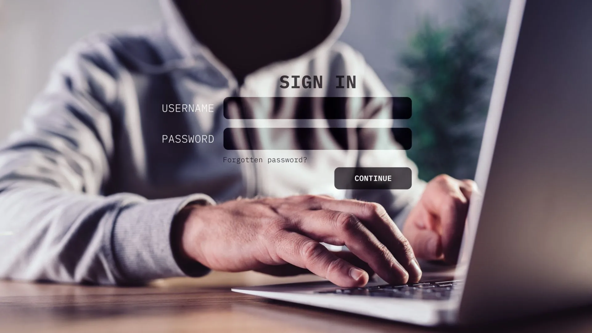 Hacker đội mũ trùm lén lút sử dụng laptop, biểu tượng rủi ro bảo mật